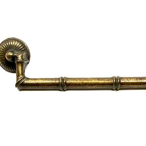 May include: A brass-toned metal drawer pull with a bamboo-inspired texture and two circular, ribbed mounting plates. The handle features a hinged design and is accompanied by two silver-colored metal mounting screws for installation.
