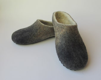 May include: A pair of gray and white wool felt slippers with a black rubber sole.