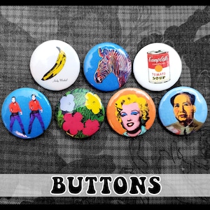 May include: Set of seven colorful button pins featuring various pop art images, including a banana, a zebra, a can of Campbell's Tomato Soup, two men in red jackets, flowers, Marilyn Monroe, and Mao Zedong.