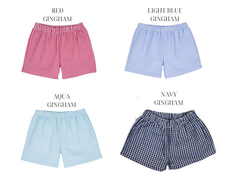May include: Four pairs of gingham shorts in different colors: red, light blue, aqua, and navy. Each pair has an elastic waistband and a checkered pattern.