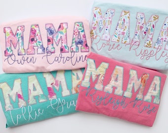 May include: Four pink, blue, and turquoise t-shirts with the word "MAMA" spelled out in large, colorful letters. Each shirt has a different name embroidered underneath the word "MAMA".