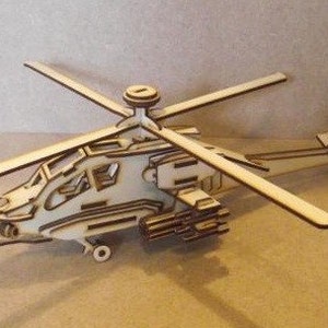 May include: A wooden model of a helicopter with a detailed design. The model is made of light brown wood and has a rotor on top.