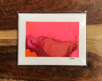 Op de afbeelding: Een abstract schilderij in roze en rood op een witte kaart met het woord "tame" in zwarte inkt onderaan.