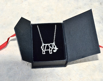 May include: A silver origami elephant necklace in a black velvet box with a red ribbon.