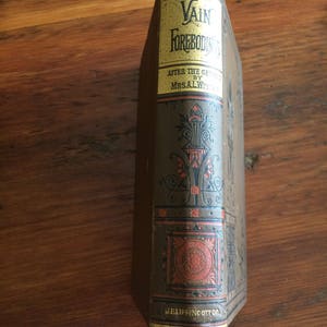 May include: A vintage book titled "Vain Forebodings" by Mrs. A.L. Wister. The book's spine is brown with gold and red decorative elements. The title is in gold lettering on a yellow background. The publisher's name, J.B. Lippincott Co., is at the bottom.