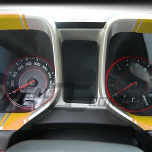 May include: A car dashboard with two gauges, one showing 0 to 160 mph and the other showing 0 to 9. Both gauges have yellow and orange stripes on the face.