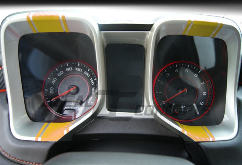 May include: A car dashboard with two gauges, one showing 0 to 160 mph and the other showing 0 to 9. Both gauges have yellow and orange stripes on the face.