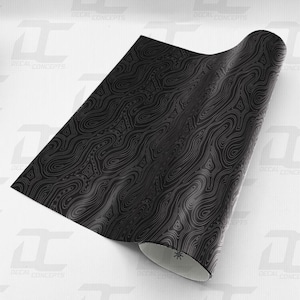 May include: Black and white patterned vinyl wrap with a topographic design. The vinyl is rolled up and the pattern is visible on the surface.