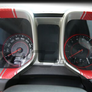 May include: Close-up of a car's dashboard with two gauges. The gauges have red and silver accents. The left gauge reads up to 160 and the right gauge reads up to 9.