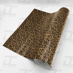Könnte beinhalten: Eine braune und schwarze Vinylfolie mit Leopardenmuster. Die Folie ist aufgerollt und das Muster ist auf der Oberfläche sichtbar.
