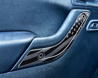 May include: A black and silver car door handle with a black and white American flag design.
