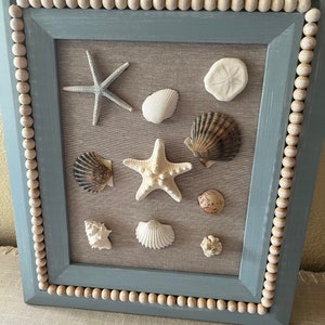 Arte della parete con mosaico di conchiglie, tema spiaggia costiera blu e bianca