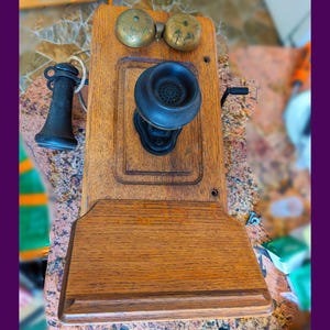 Century-old, hand-cranked, oak shell, wall telephone (with writing shelf) in excellent condition