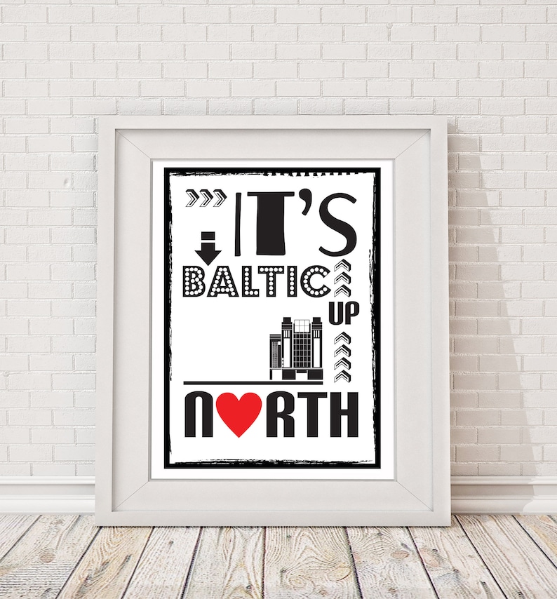 以下が含まれることがあります： 「It's Baltic Up North」というテキストが書かれた白黒のタイポグラフィー印刷。赤いハートが「North」の「O」を置き換えています。