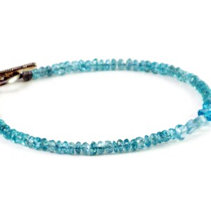 May include: A delicate blue topaz gemstone bracelet with a silver toggle clasp.