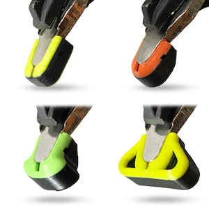 May include: Four metal pliers tips fitted with custom 3D-printed protective covers. The covers come in bright neon yellow, orange, and light green, featuring distinct geometric shapes that snap onto the metal jaws of the hand tools.