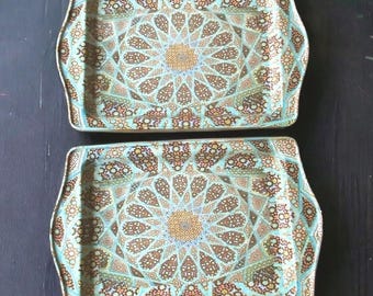 May include: Two rectangular serving trays featuring a light blue background with a complex, repeating geometric star pattern in shades of brown, gold, and white. Each tray has slightly curved side edges and a flat, wide surface area.