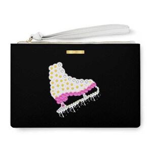 May include: Black clutch purse with a white zipper and a white handle. The front of the purse features a white and pink ice skate made of flowers.