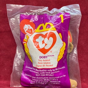 May include: Sealed Ty Doby toy animal from McDonald's. The purple plastic bag features the McDonald's logo and the Ty heart logo. Text on the bag includes "Toy Animal" and "Not for Resale."