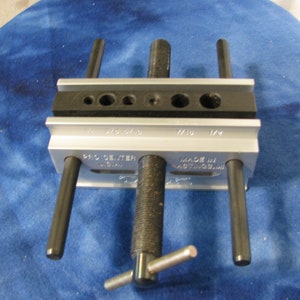May include: A silver and black Pro Center tool with multiple holes and black rods. The tool has the text "PRO CENTER USA" and "MADE IN HASTINGS, MI" printed on it. The tool is designed for precision work.