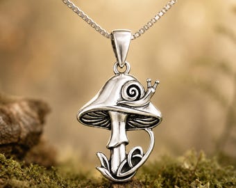 May include: A silver-toned pendant shaped like a mushroom with a small snail resting on the cap. The mushroom features detailed gills underneath the cap and a curved stem base. The pendant hangs from a thin silver-toned box chain necklace.