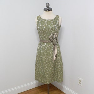 Vestido de coquetel brocado dos anos 1960 com cós de cetim e laço lateral.