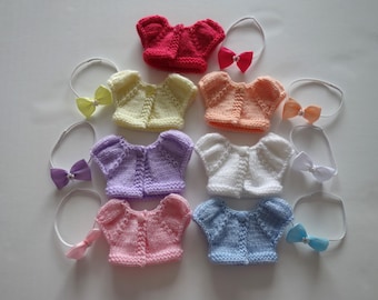 Hand knitted short puff sleeved cardigan/sweater with hair bow to fit 8 inch doll.  Doll not included. Free UK del.