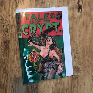 Può includere: Una copertina di fumetto vintage che mostra una donna attaccata da una creatura mostruosa. La copertina è rossa e verde con il titolo "Tales From The Crypt" e la parola "Terror" che scorre lungo il lato. La copertina del fumetto costa 10 centesimi.