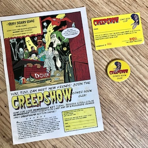 Può includere: Kit di iscrizione al Creepshow Comic Book Club, che include una tessera, un bottone e un volantino. Il volantino presenta illustrazioni di fumetti con il testo "A Very Scary Comic Book Club!!" e "Creepshow Comic Book Club!"