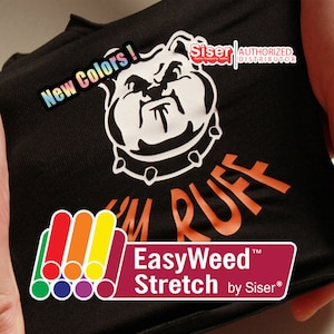 May include: A black t-shirt with a white bulldog graphic and the text "I'm Ruff" in orange. The text "EasyWeed Stretch by Siser" is on a red and white label. The image also shows a rainbow of colors, indicating the availability of different colors of heat transfer vinyl.