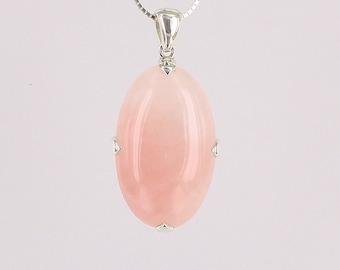 May include: A silver chain necklace with a pink oval pendant. The pendant is set in silver with small silver accents around the edge. The pendant is a light pink color and has a smooth, polished finish.