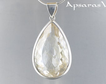 May include: A silver teardrop-shaped pendant with a clear quartz stone featuring golden inclusions. The pendant is on a silver chain.