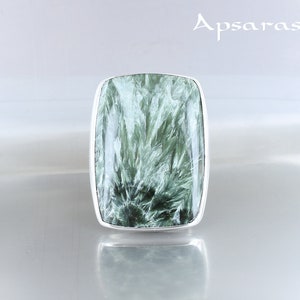 May include: A silver ring with a green and white gemstone. The gemstone has a unique, swirling pattern.