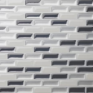May include: A rectangular wall tile pattern featuring a repeating brick layout. The individual tiles have a glossy, beveled finish in alternating shades of dark charcoal gray, light gray, and white, creating a high-contrast, monochromatic grid.