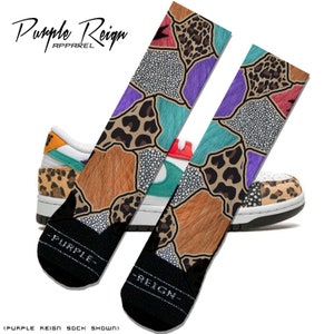May include: A pair of colorful socks with a patchwork design featuring leopard print, fur, and a speckled pattern. The socks are shown with a white sneaker with a similar patchwork design.