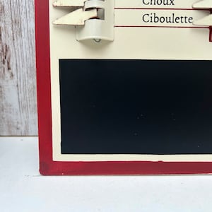 Op de afbeelding: Een rood en wit krijtbord met een zwart krijtbord inzetstuk. Het bord heeft een witte rand en de woorden "Choux Cibulette" in zwart.