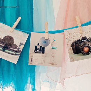 K&ouml;nnte beinhalten: Drei Fotos werden auf einem blauen und rosa T&uuml;llhintergrund angezeigt. Das erste Foto zeigt einen Stapel Schokoladen-Sandwich-Kekse mit gr&uuml;ner Minzf&uuml;llung. Das zweite Foto zeigt eine Vintage-Kamera mit Blitz und einer Flasche. Das dritte Foto zeigt eine schwarze Nikon-Kamera mit einem silbernen Objektiv.