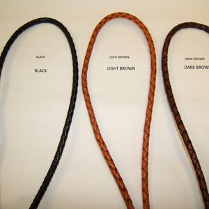 May include: Three braided leather cords in black, light brown, and dark brown. The text "BLACK", "LIGHT BROWN", and "DARK BROWN" are above each cord. The cords are likely for jewelry or crafting.