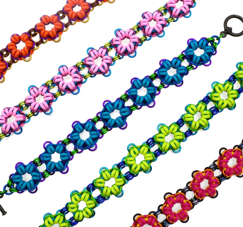 May include: Five colourful bracelets made of linked metal rings in the shape of flowers. The bracelets are in shades of orange, pink, teal, green, and magenta.