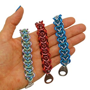 Puede incluir: Tres pulseras de malla de cadena en diferentes colores. Las pulseras est&aacute;n hechas de anillos de metal y tienen un cierre de metal martillado. Las pulseras son azules, rojas y verdes.
