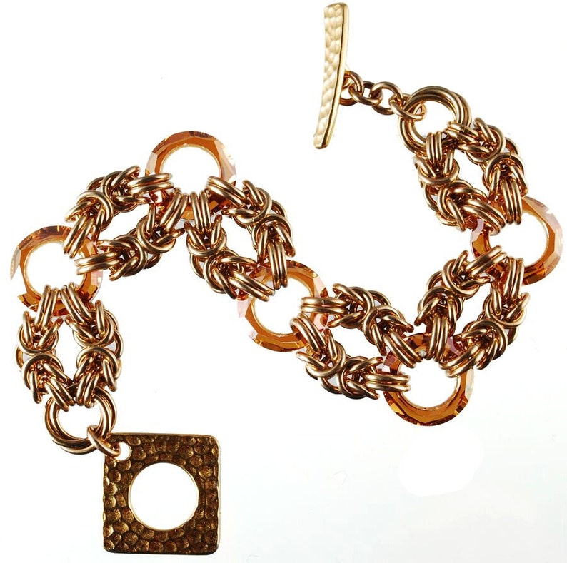 May include: A gold bracelet with a square clasp and amber-colored glass beads. The bracelet is made of a woven chain design.