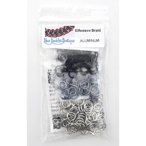 Puede incluir: Una bolsa de pl&aacute;stico transparente que contiene un kit para hacer una trenza Elfweave. El kit incluye anillos met&aacute;licos negros, plateados y azules. La bolsa tiene una etiqueta que dice "Elfweave Braid" y "Blue Buddha Boutique ALUMINUM".
