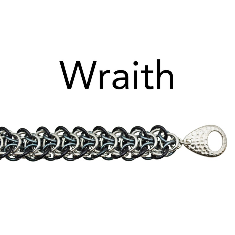 Puede incluir: Un brazalete de malla de cadena negro y plateado con un cierre de plata martillado. El brazalete est&aacute; etiquetado como "Wraith".