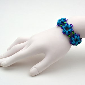 May include: A blue and purple wire bracelet with turquoise flower-shaped beads.