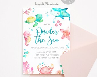 Può includere: Un invito ad acquerello con il tema "Sotto il mare", con creature marine come una tartaruga, un cavalluccio marino e un granchio. L'invito include il testo "Oneder The Sea" e i dettagli dell'evento, con una busta rosa in primo piano.