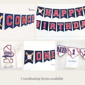 May include: Baseball-themed birthday party decorations, including a banner that says "Happy Birthday", a banner that says "One", and a number one cake topper. The banners are navy blue and red with white stitching and baseball graphics.