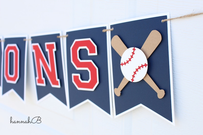 May include: A navy blue banner with red letters spelling "SONS" and a baseball and crossed bats on the right side.