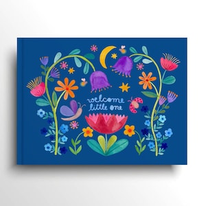 Pode incluir: Uma capa de livro azul marinho com um design floral em aquarela. O design inclui flores, borboletas e o texto "welcome little one". A paleta de cores inclui rosa, laranja, roxo e amarelo.