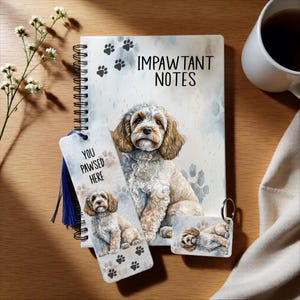May include: A stationery set featuring a dog illustration. The set includes a spiral-bound notebook with "IMPAWTANT NOTES", a bookmark with "YOU PAWSED HERE", and a keychain. All items feature paw prints and a watercolor image of a dog.