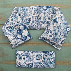 May include: Three blue and white patterned fabric neck wraps for hot or cold therapy. The wraps are rectangular and have a floral design.